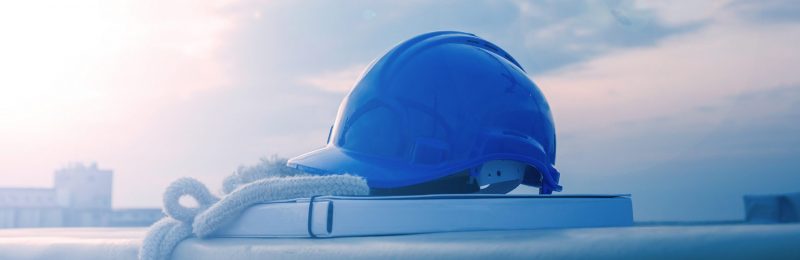 Blue hard hat on design papers