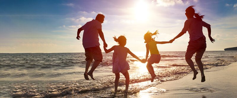 Family jumping on the beach